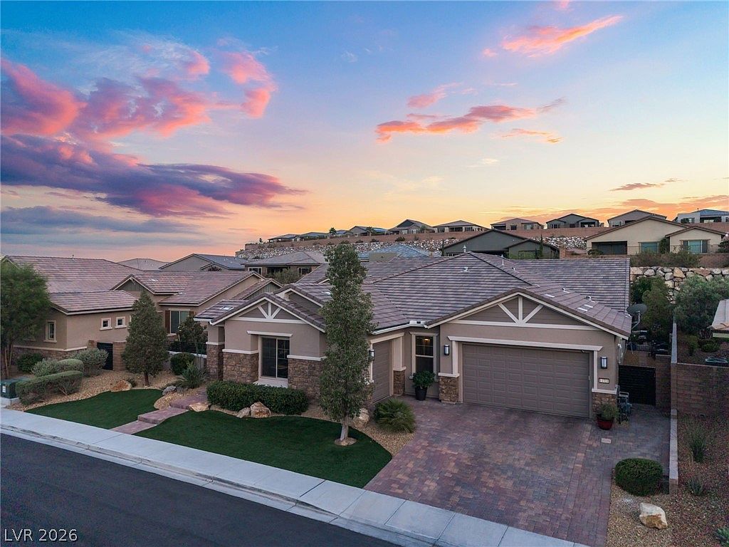 Aerial twilight photograph showing the home from above, the tile roof against the hillside community of Reverence with mountain ridgelines on the horizon and a pink sunset sky